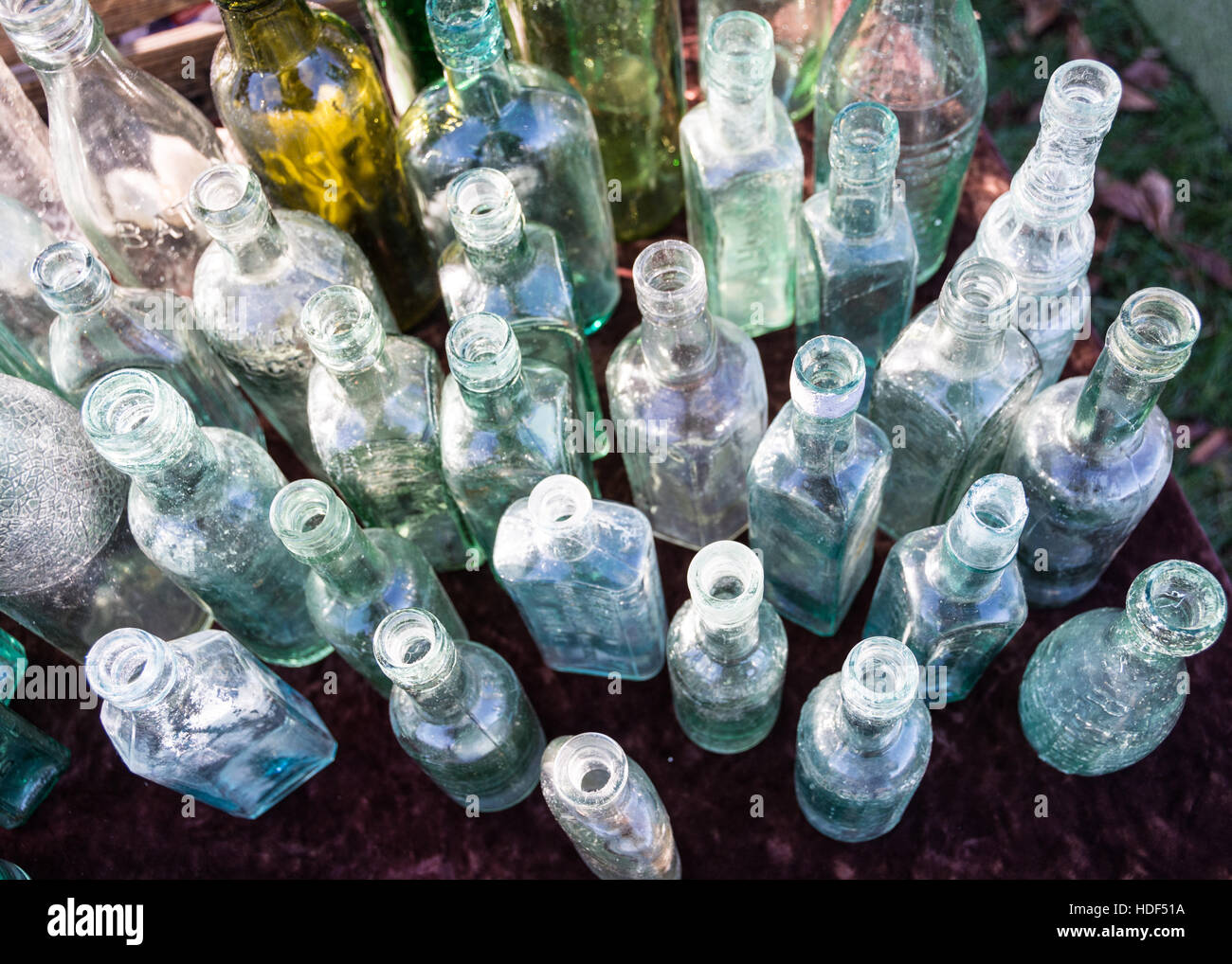A row of Victorian glass bottles on a table at a car boot sale in London, England, UK Stock Photo