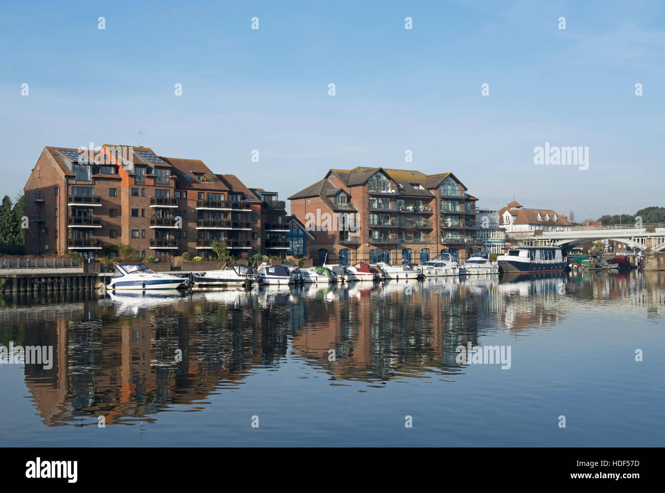 view from kingston bridge, surrey, england, across the river thames to flats and moored boats at hampton wick Stock Photo