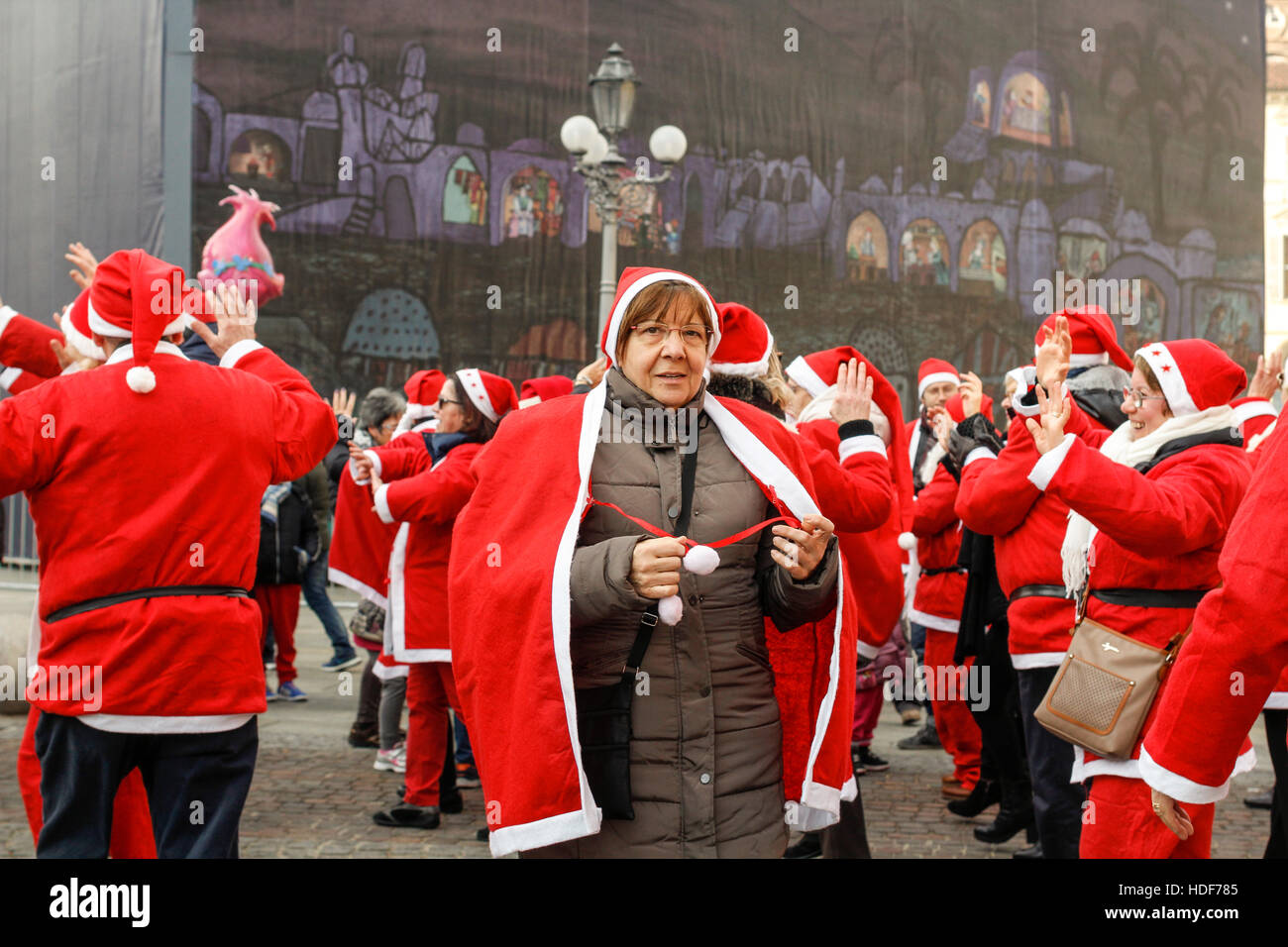 People dancing with Santa Claus costumes, Turin, Italy Stock Photo