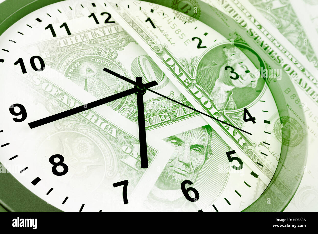 Clock on assorted American banknotes. Time is money idea Stock Photo ...