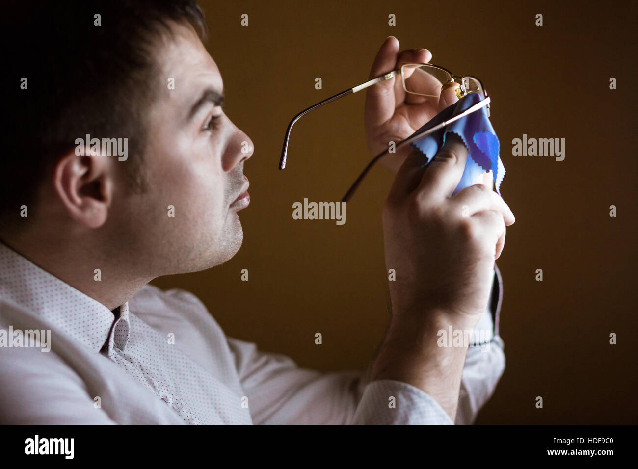 Man cleaning a softie lens of computer glasses Stock Photo
