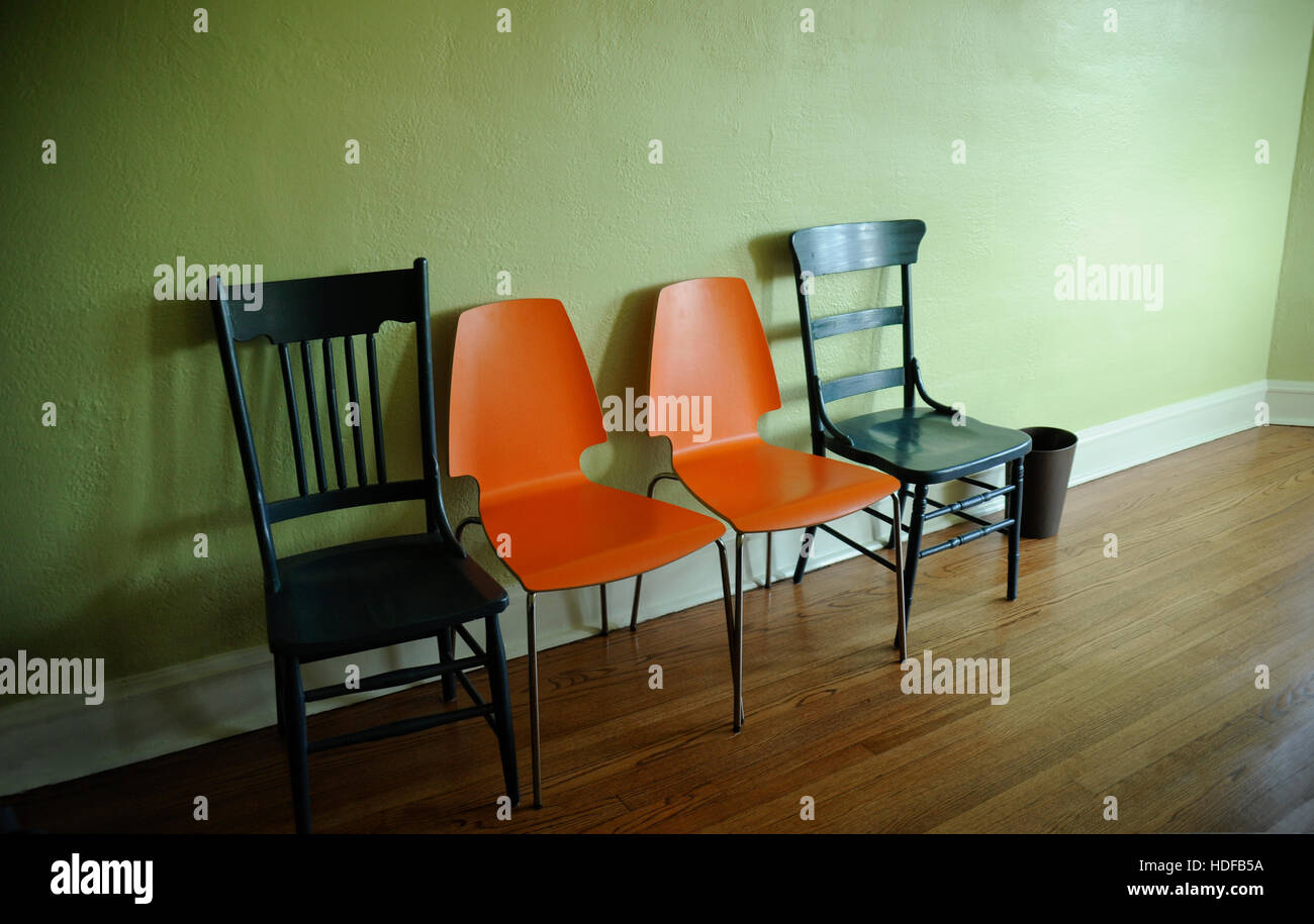 modern and old chairs against wall Stock Photo Alamy