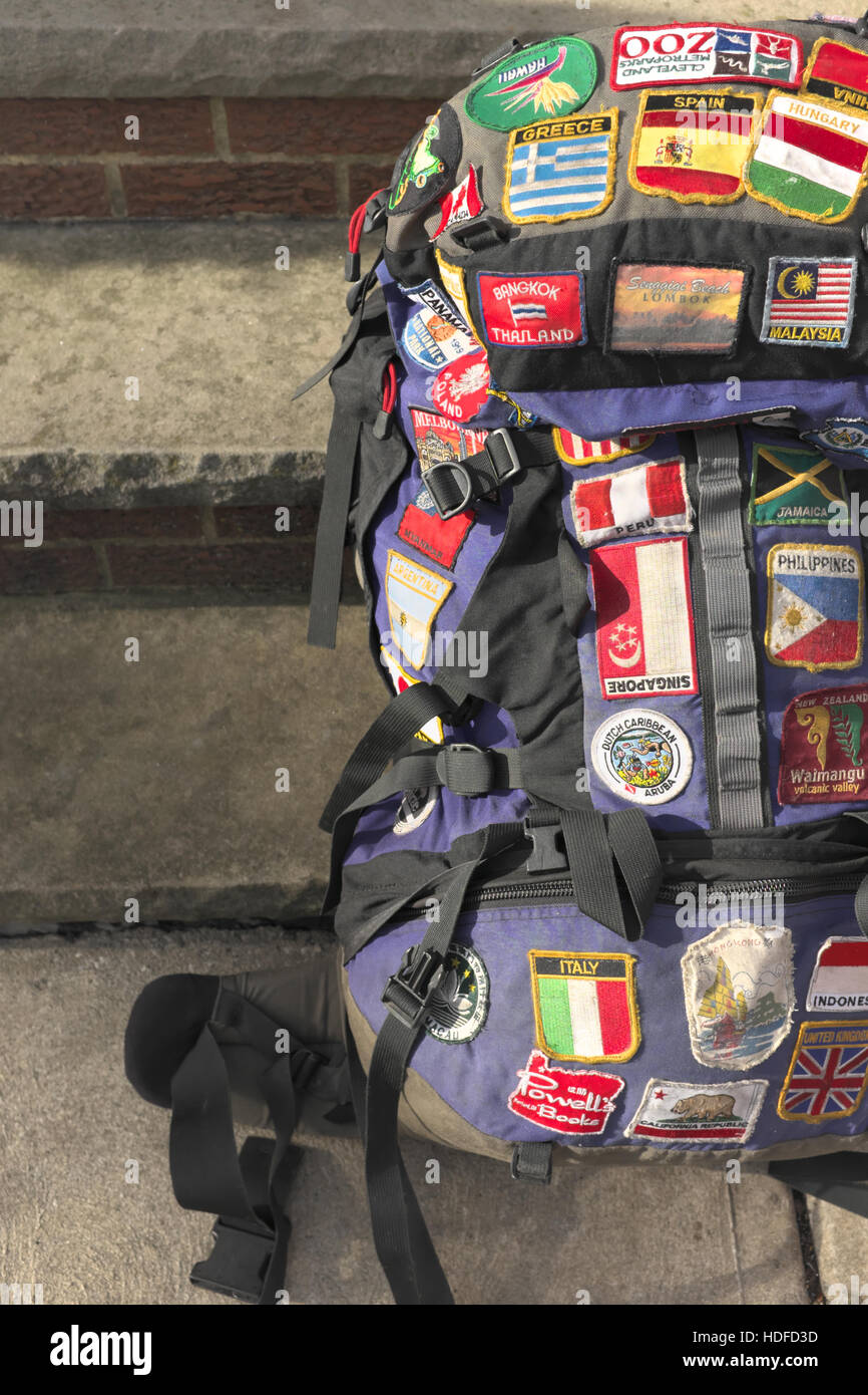 Well used world travelers backpack with patches sewn on reflecting the destinations the traveler has been to. Half of pack shown Stock Photo