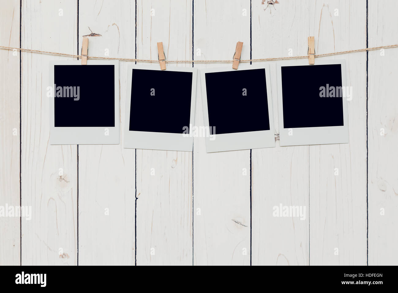 Four blank photo frame hanging on white wood background with space Stock Photo