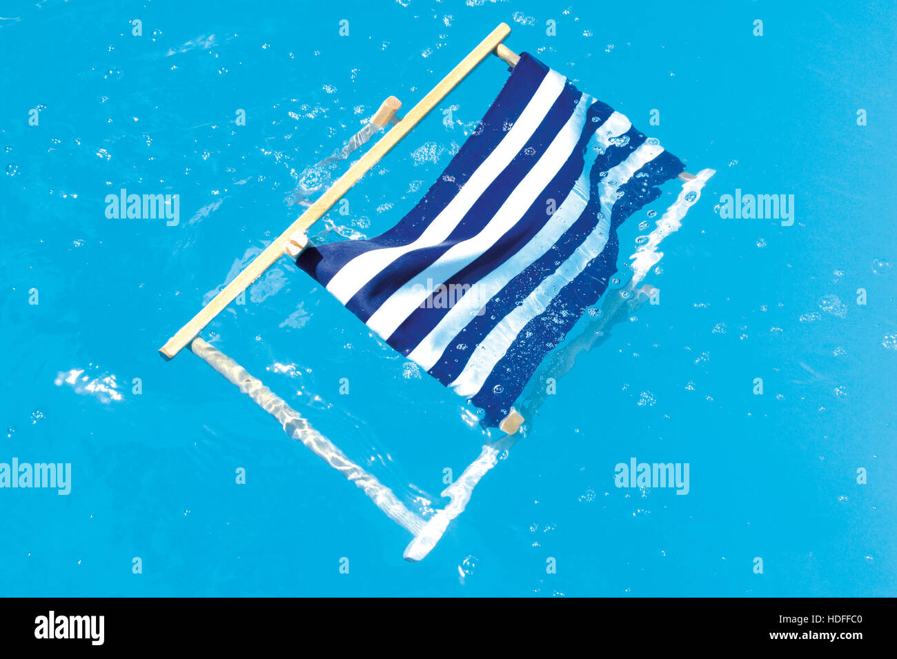 Deckchair in a pool, symbolic for a disasterous holiday Stock Photo