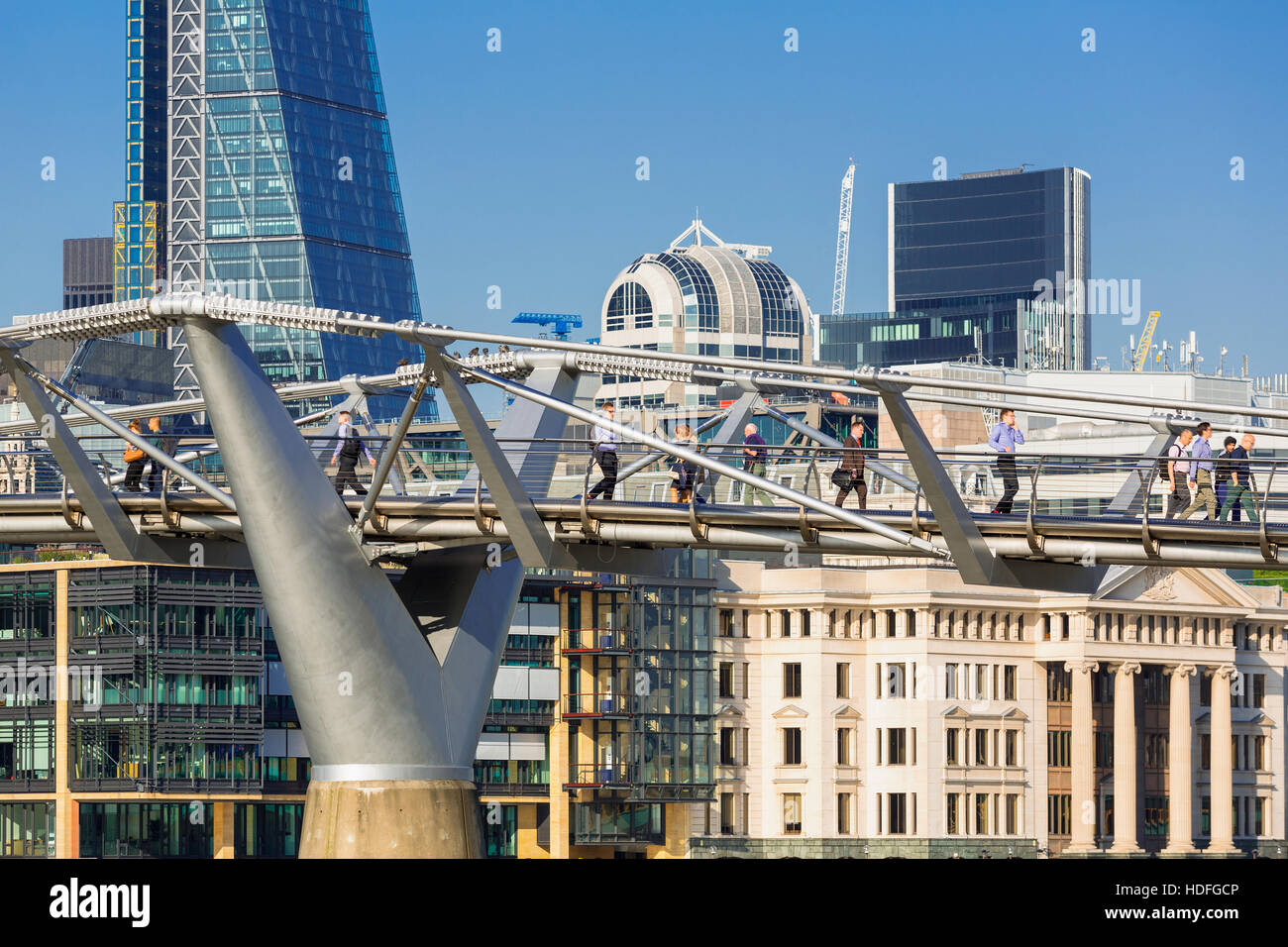 LONDON, UK. Tourists on pebble beach by Thames with Millennium Bridge and city skyline Stock Photo