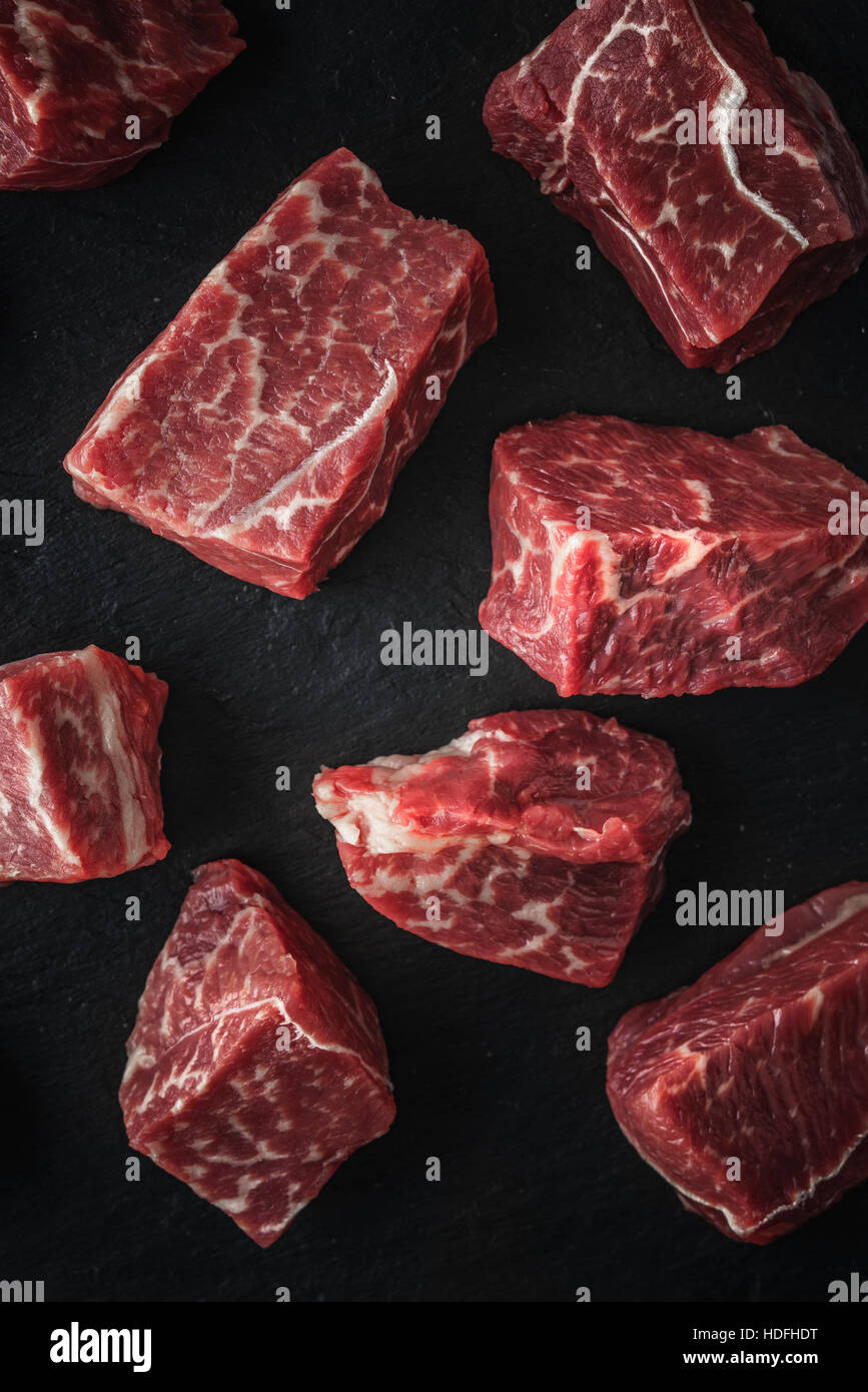 Raw angus beef slices on the black stone  table vertical Stock Photo