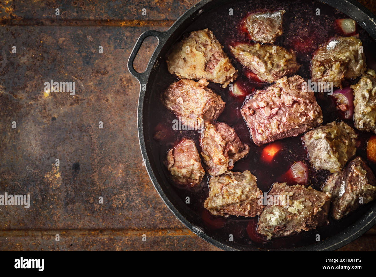 Boeuf Bourguignon in the pan on the metal background top view Stock Photo