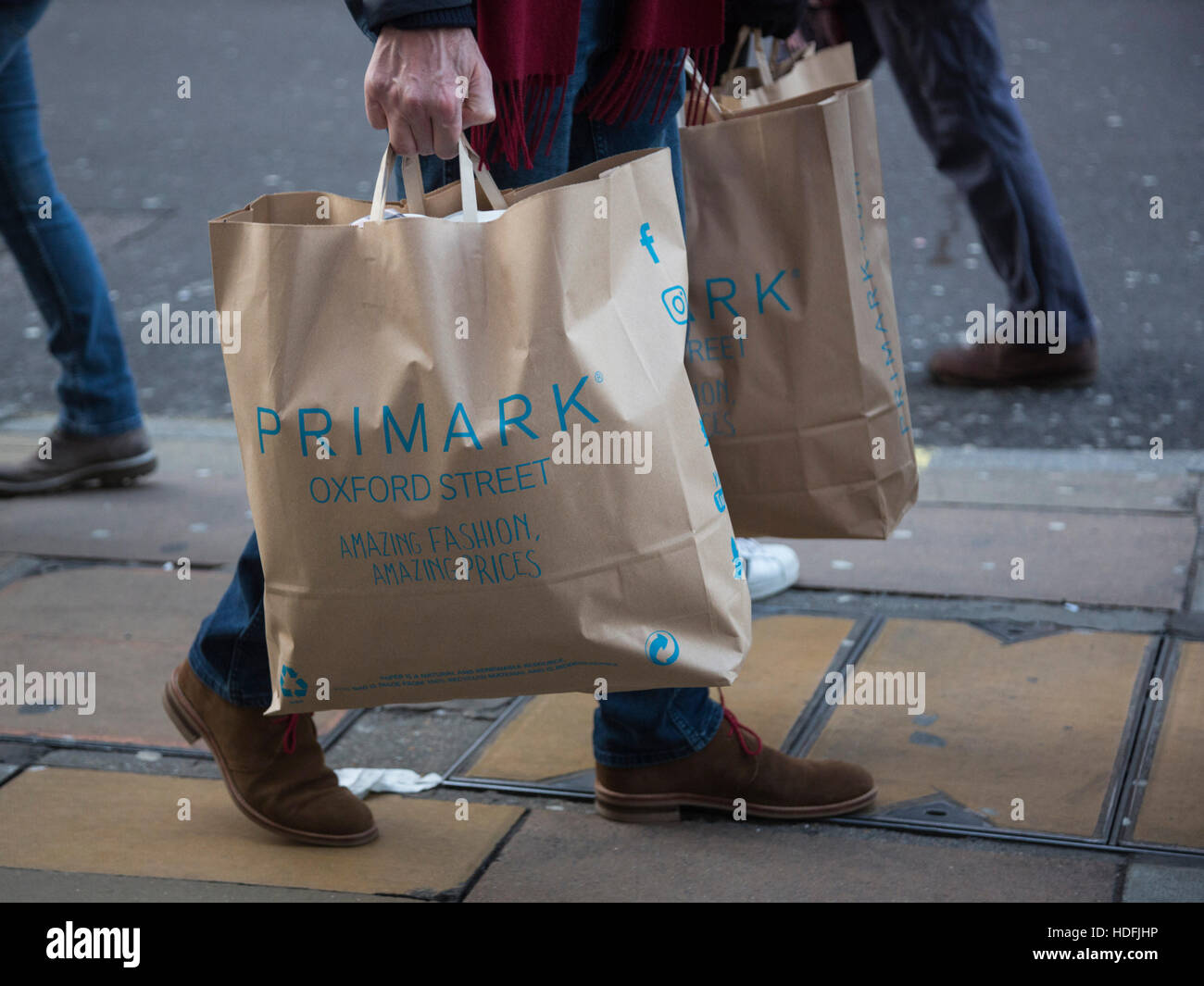Shopper carrying Primark shopping bags. Busy day on Oxford Street in ...