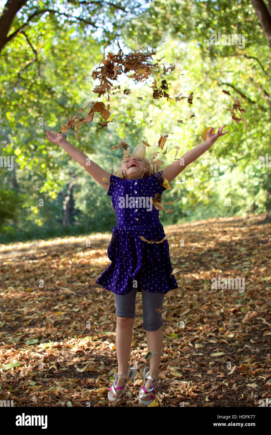 Young Girl Child Throwing Up Autumn Leaves In Early Fall Stock Photo Alamy
