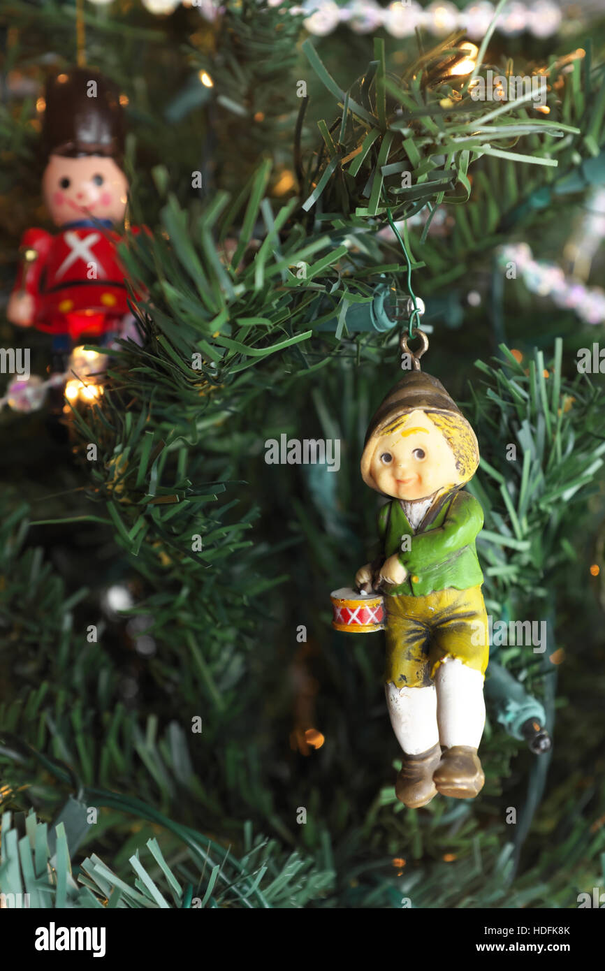 Christmas ornament hanging on tree with the focus on the little drummer boy.  A toy soldier hangs in the background. Stock Photo