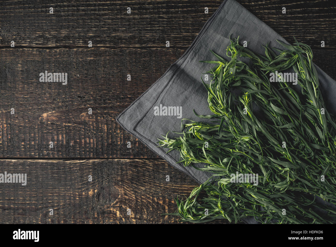 Tarragon on the grey napkin on the wooden table top view Stock Photo