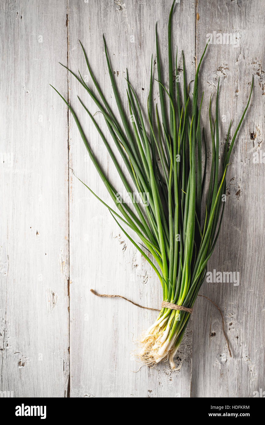 Green onion on the white wooden table top view Stock Photo - Alamy