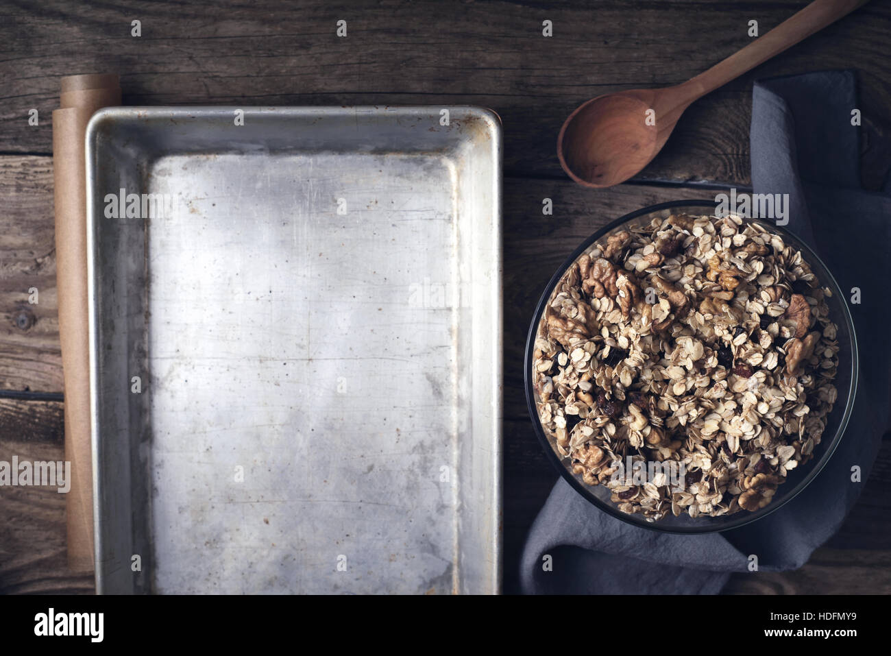 Granola in the glass bowl with baking tray on the wooden table top view Stock Photo