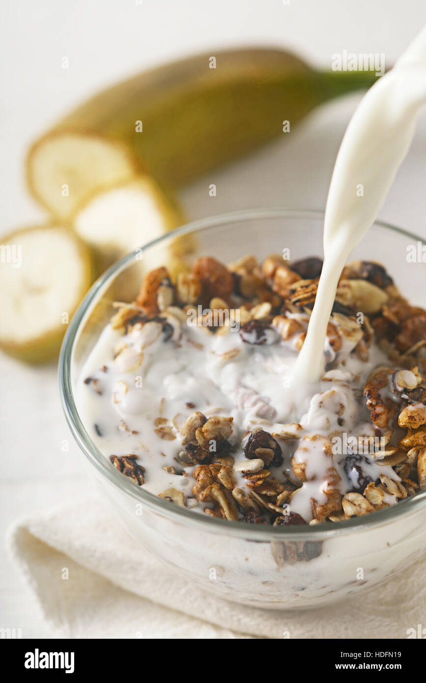 Adding yogurt to granola vertical Stock Photo