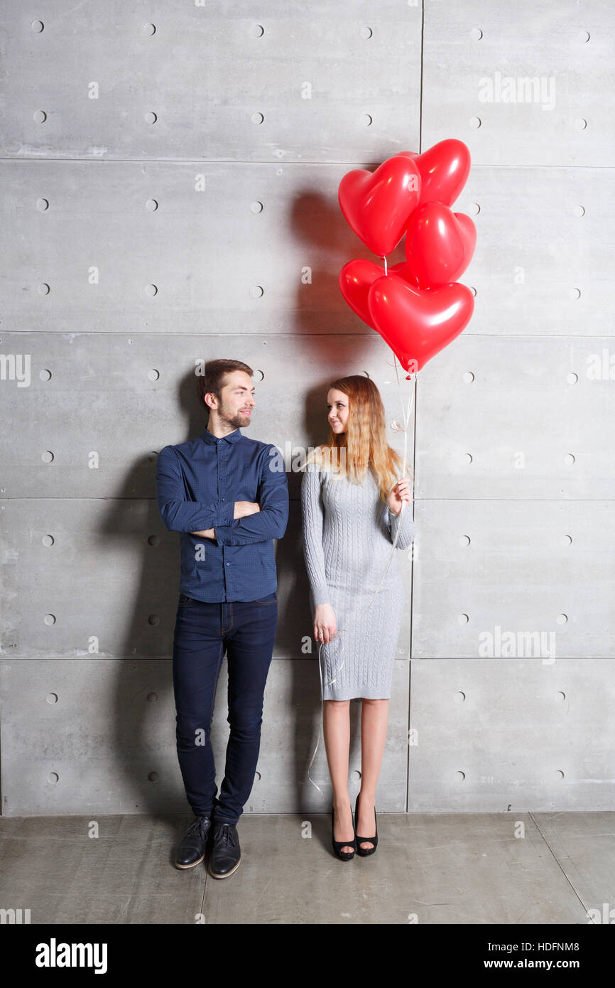Valentines day concept. Loving couple with red heart balloons on gray ...