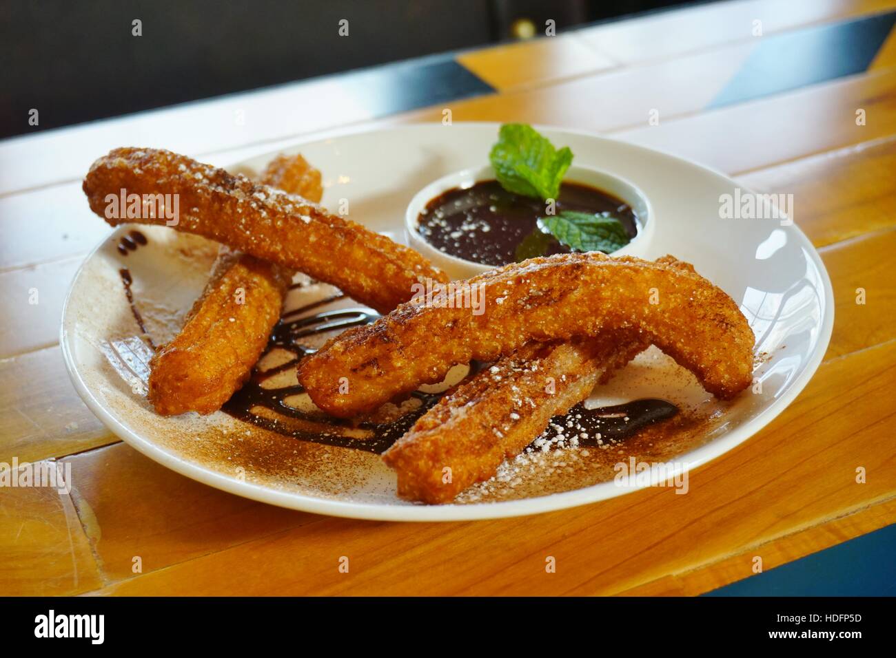 Plate of fried churro fritters with sugar and chocolate dipping sauce Stock Photo