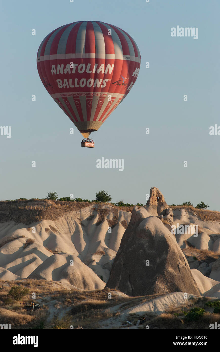 Anatolian Balloons hot air balloon floats over the outlandish, sculpted landscape of Cappadocia. Stock Photo
