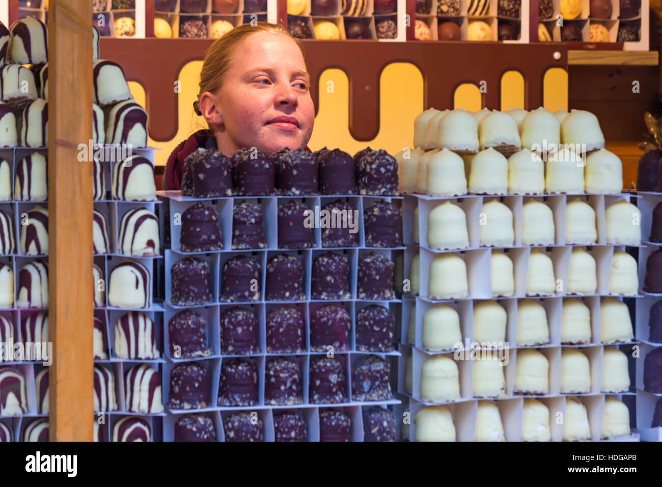 Surrounded by large chocolates! Stall holder selling large chocolates at Winchester Christmas Market, Winchester, Hampshire, England UK in December. Credit:  Carolyn Jenkins/Alamy Live News Stock Photo