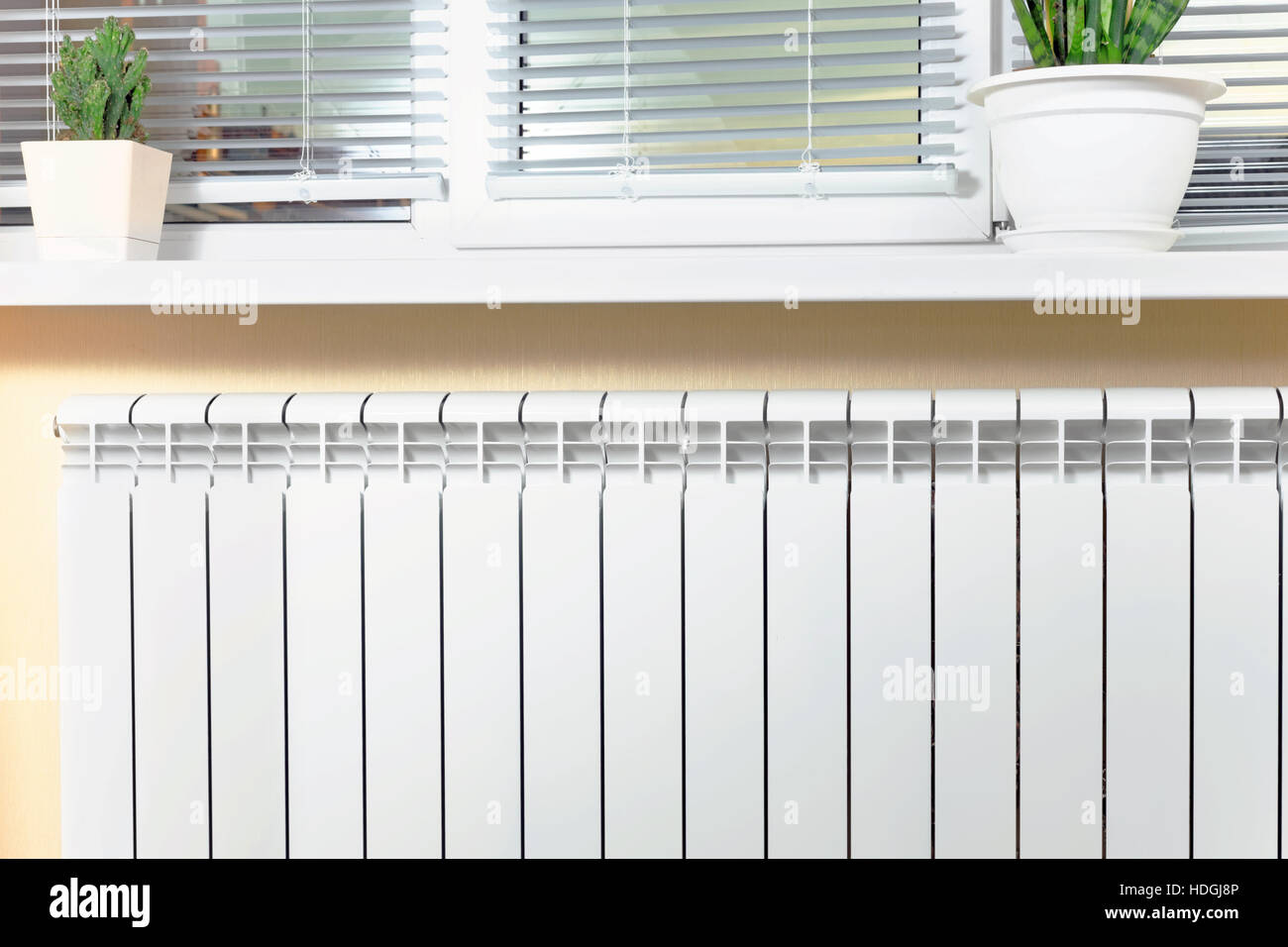 Heating white radiator radiator with flower and window Stock Photo - Alamy
