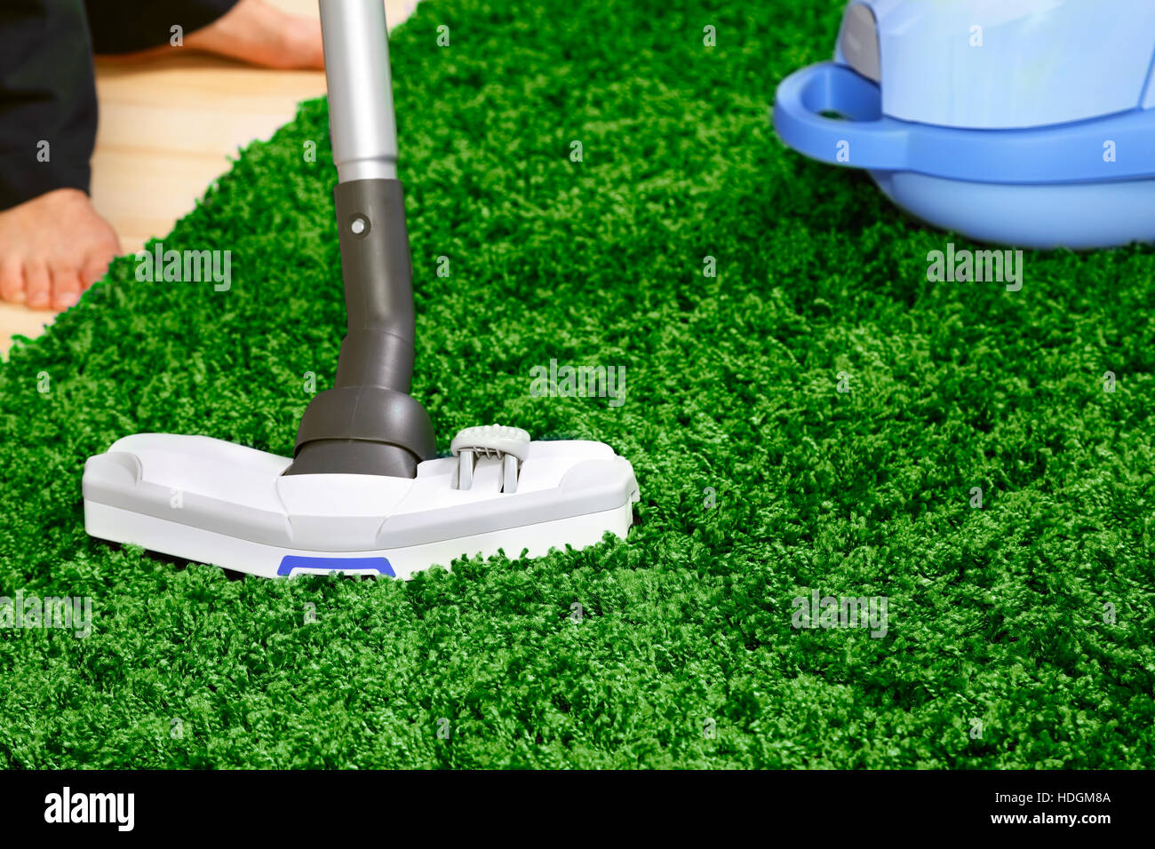 The metal pipe of vacuum cleaner in action clean a carpet and