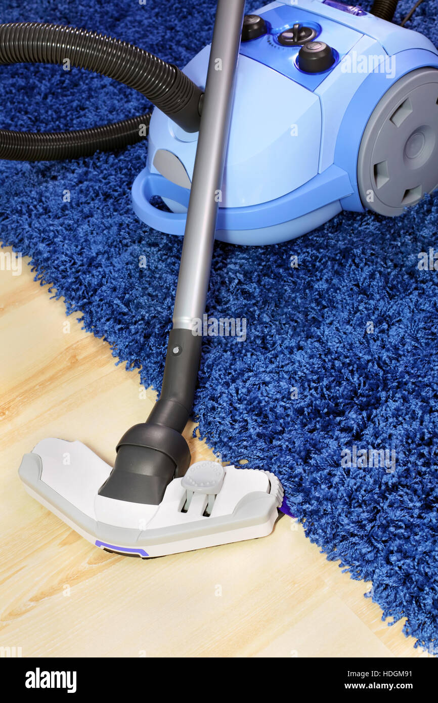 The metal pipe of vacuum cleaner in action clean a carpet and