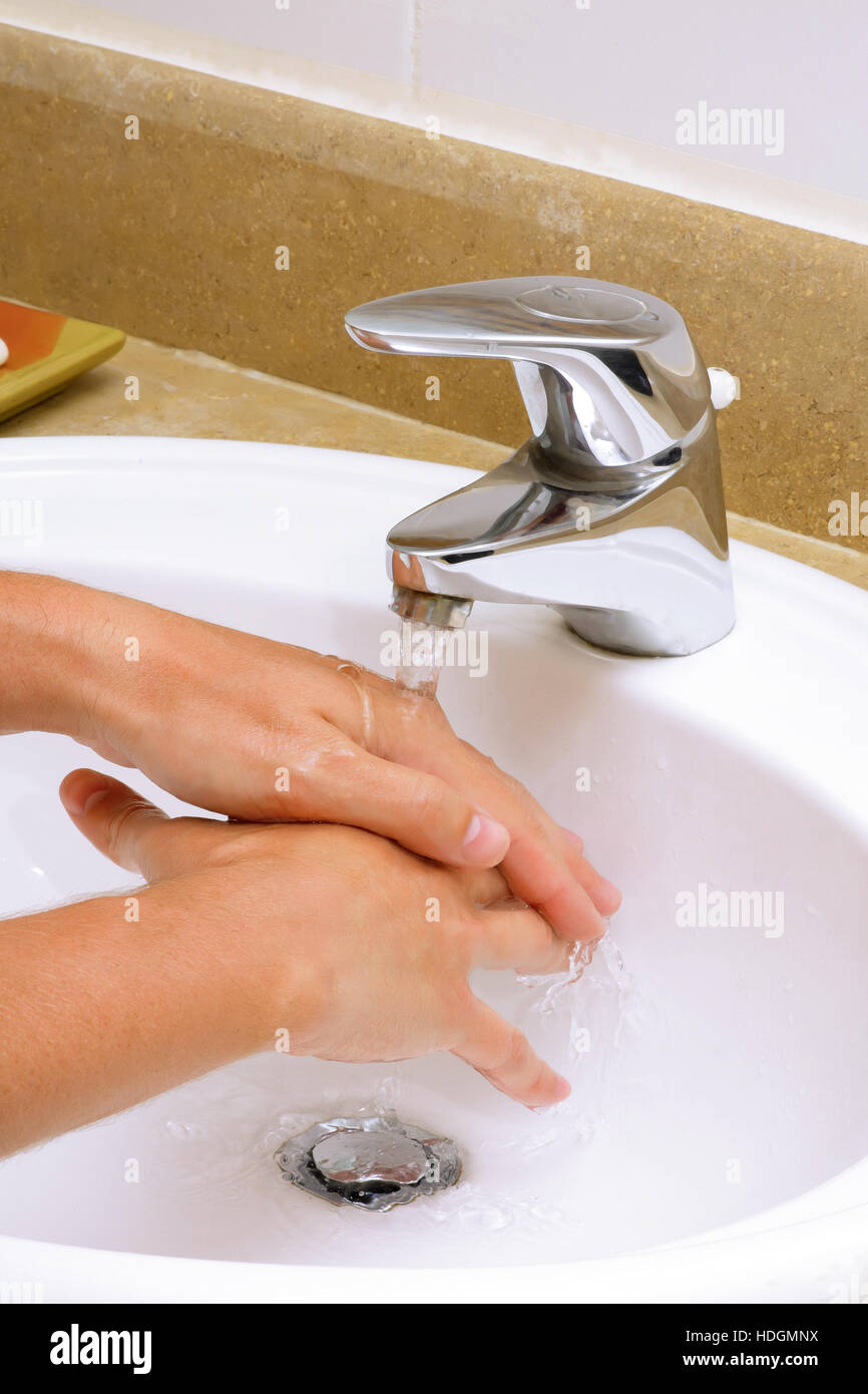 Washing hands before eating in white sink. Stock Photo