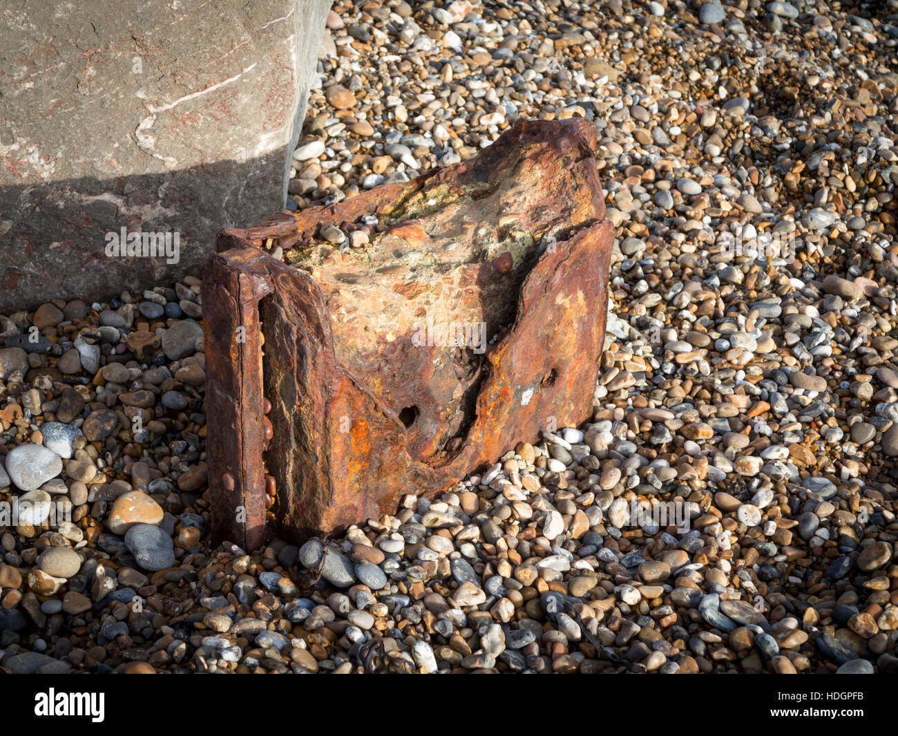 The rusted remains of sea defense structures on a pebble beach Stock Photo