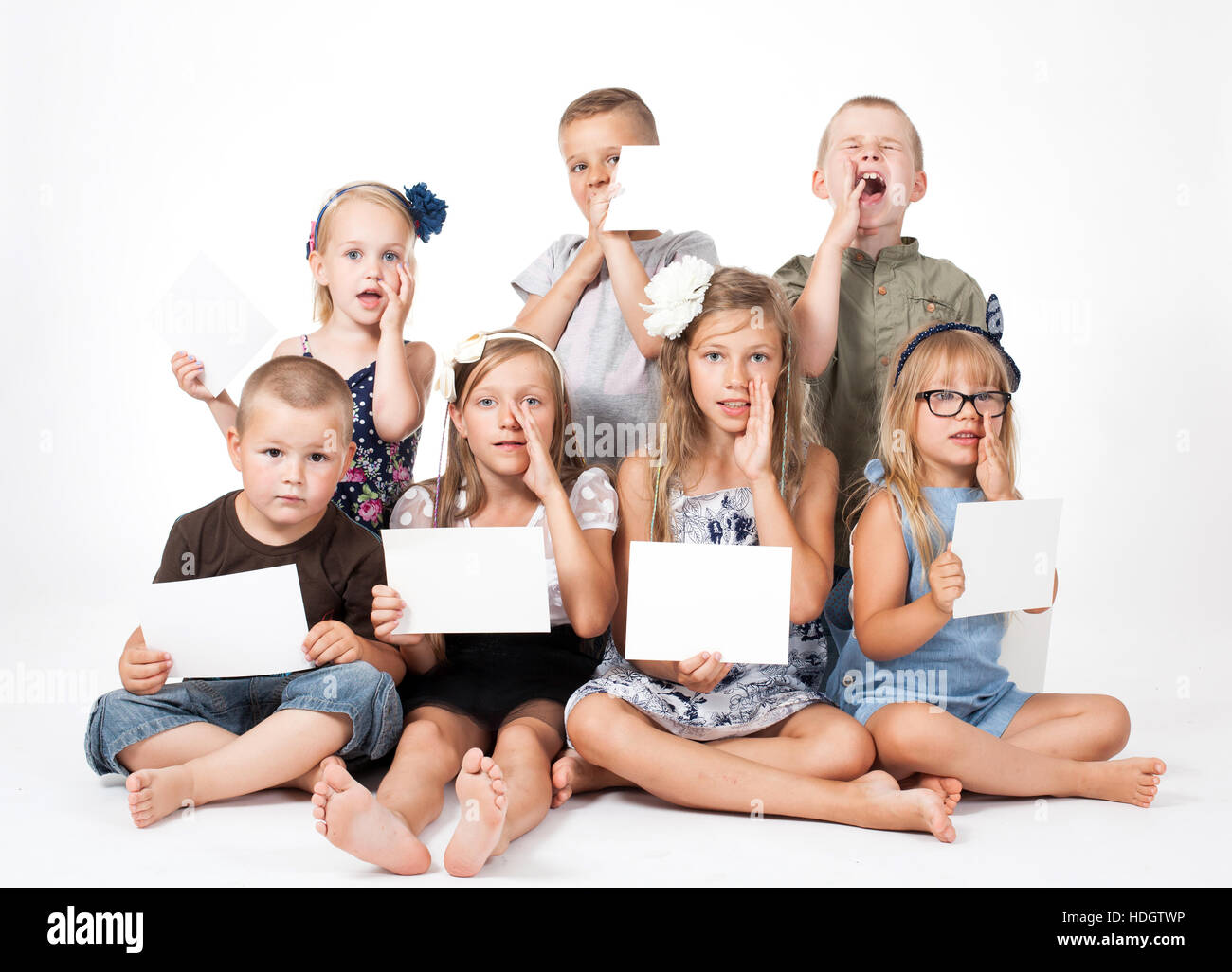a group of children holding white card Stock Photo - Alamy