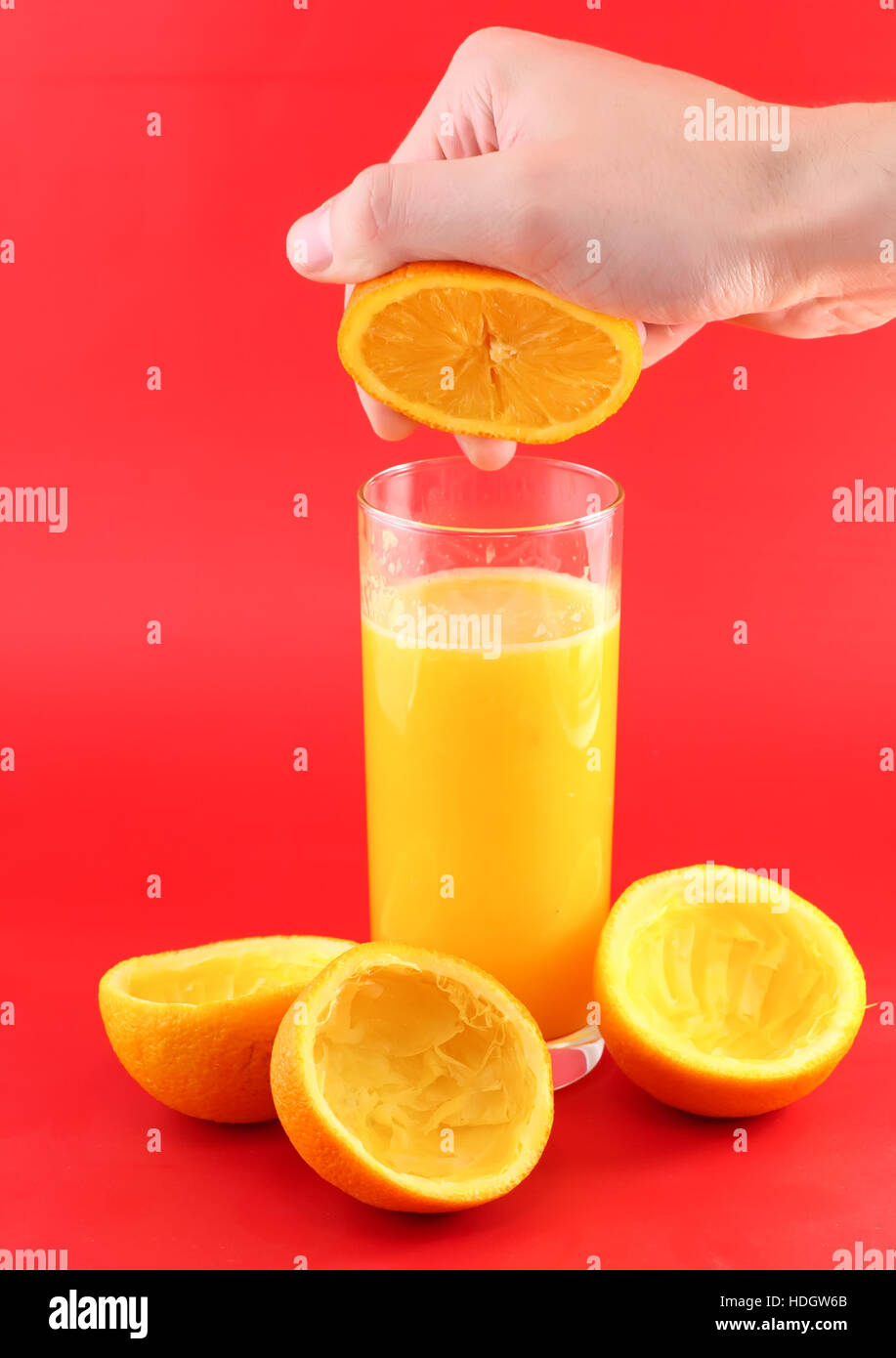 Glass of orange juice with hand, squeeze of orange Stock Photo Alamy
