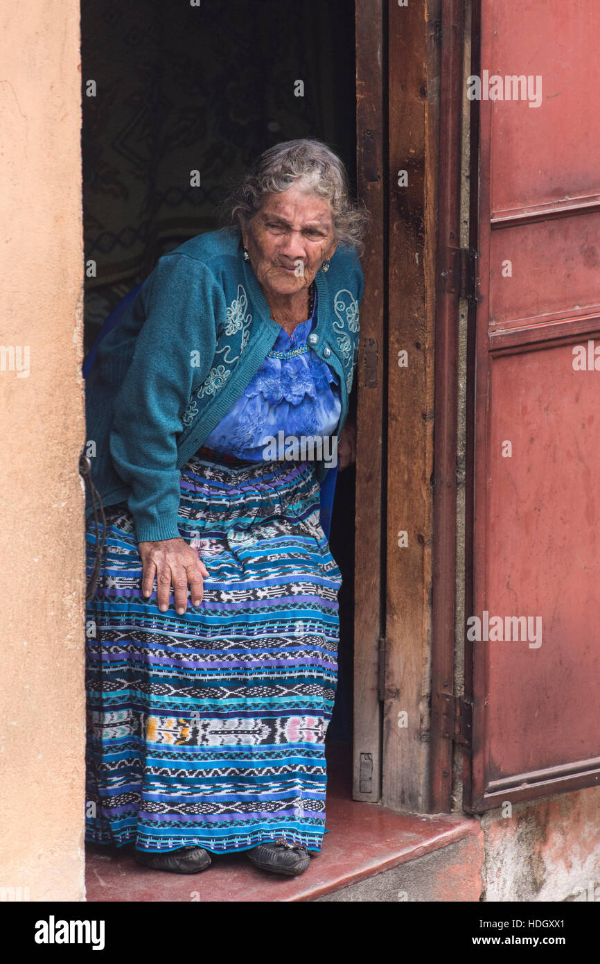 An 85 year old Mayan woman known as the Comadrona  wears traditional dress and looks out her door.  A comadrona is a midwife, and in her career, she d Stock Photo