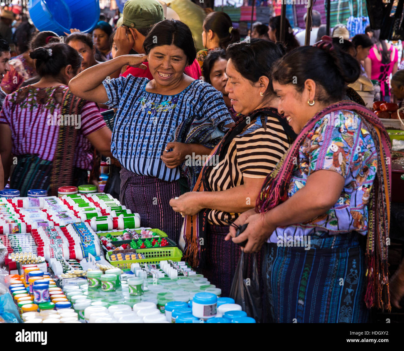 Three middle-aged adult Mayan women in traditional dress enjoy shopping at the open market in Santiago Atitlan, Guatemala. Stock Photo