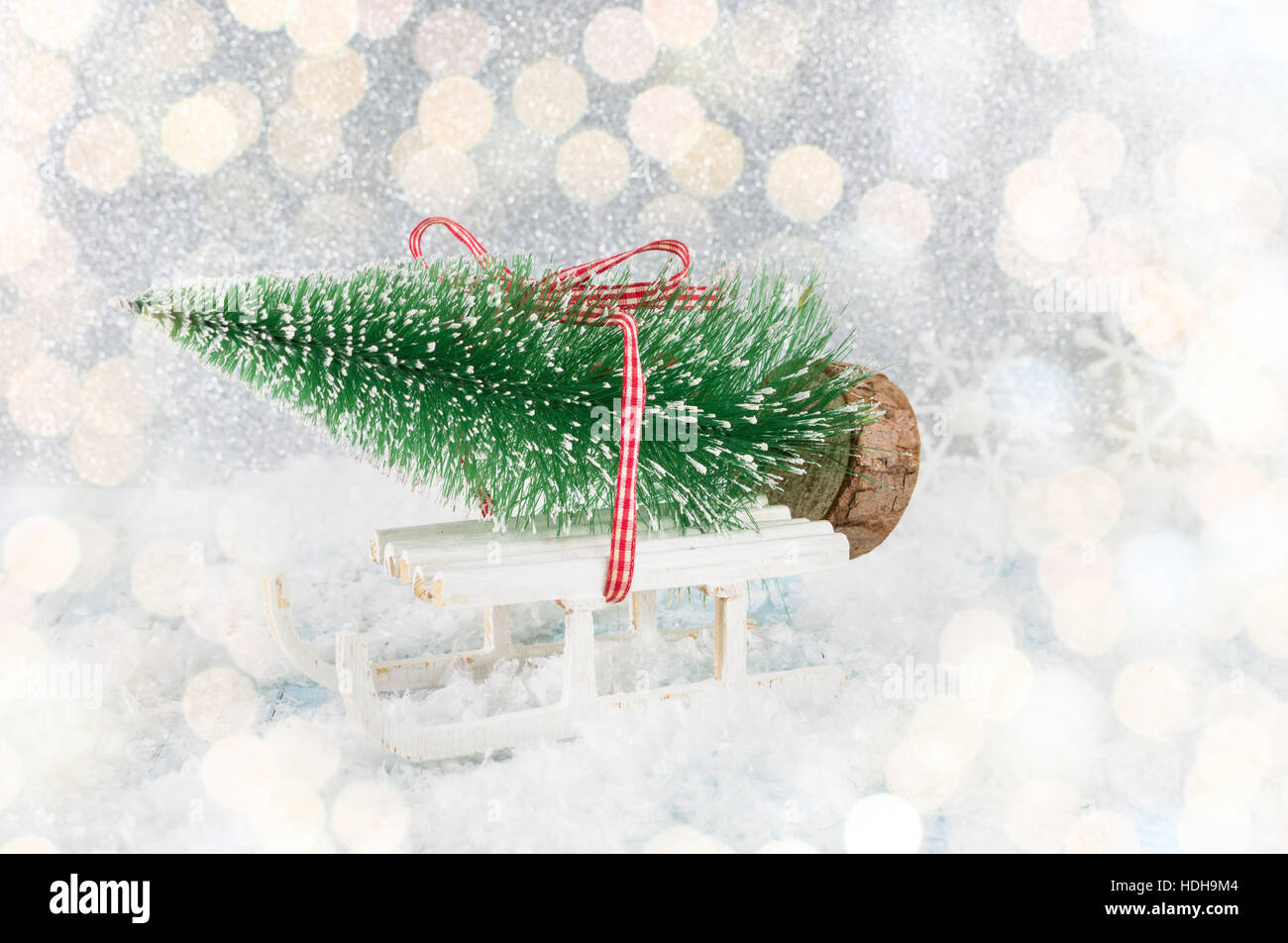 Small sleigh carrying a Christmas tree miniature Stock Photo