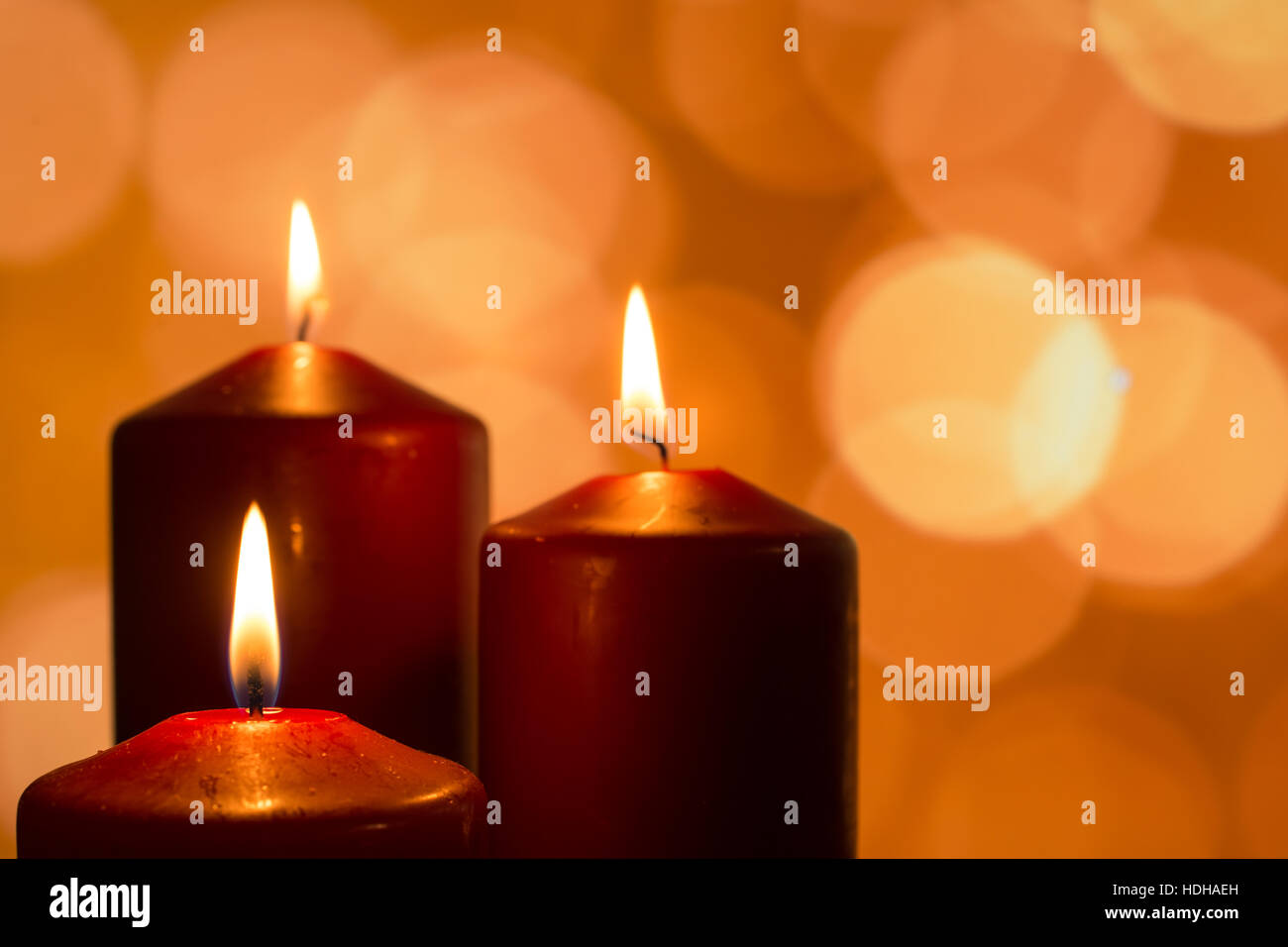 Candles with flames at reflective advent season with lights as bokeh ...