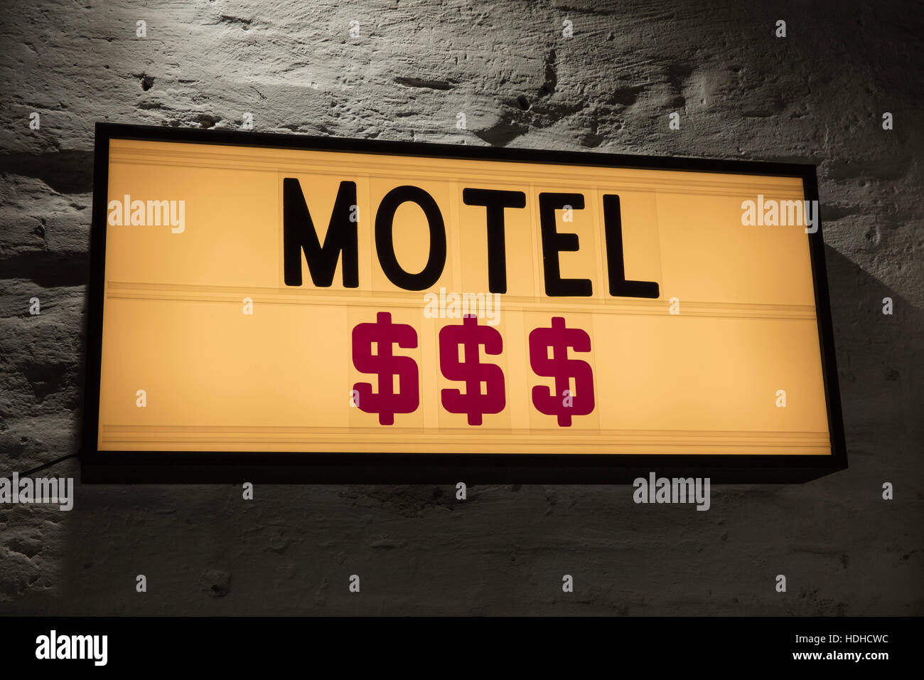 Close-up of Motel and dollar signs signboard against gray wall Stock Photo