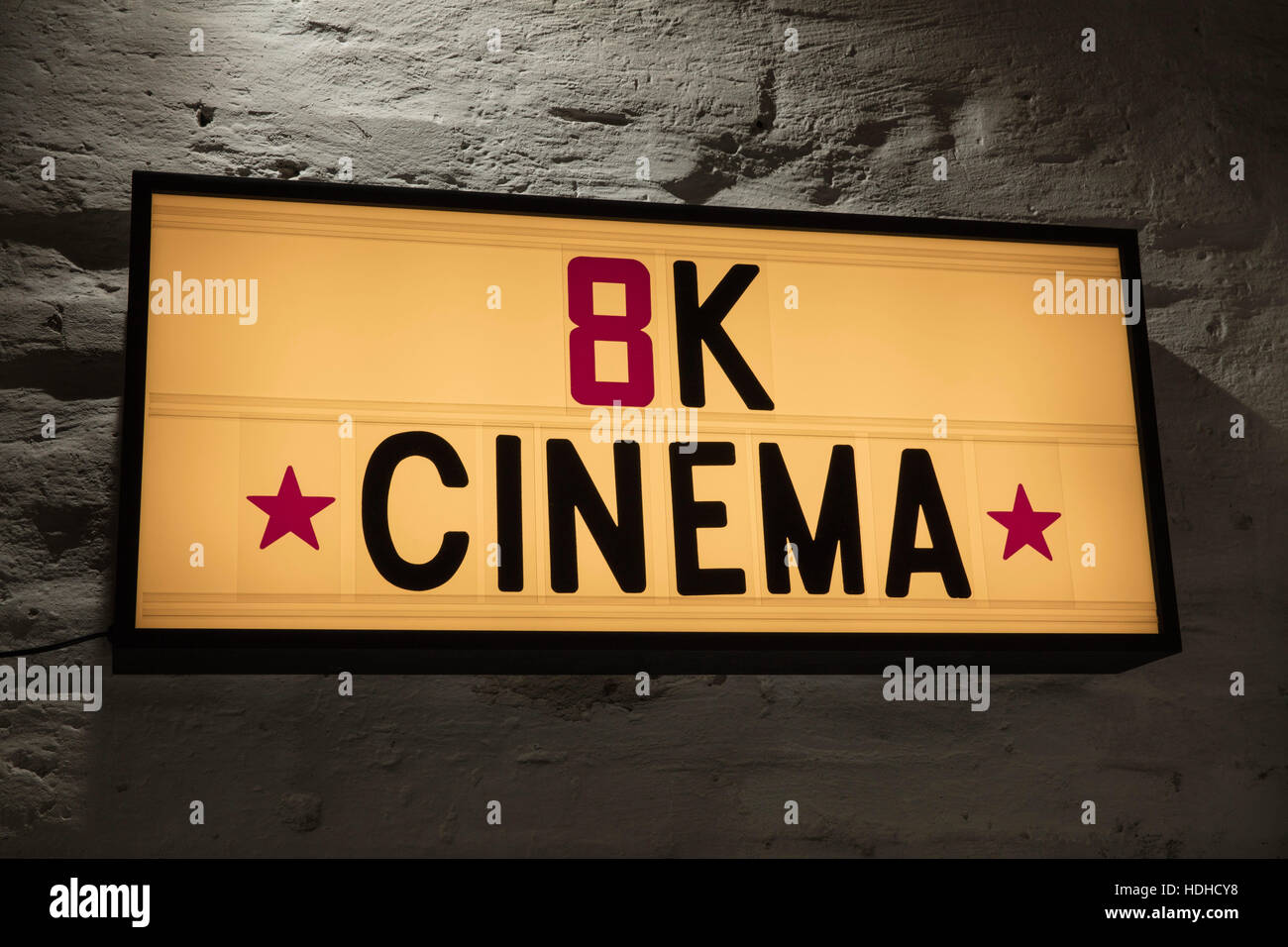 Close-up of 8K Cinema signboard against gray wall Stock Photo