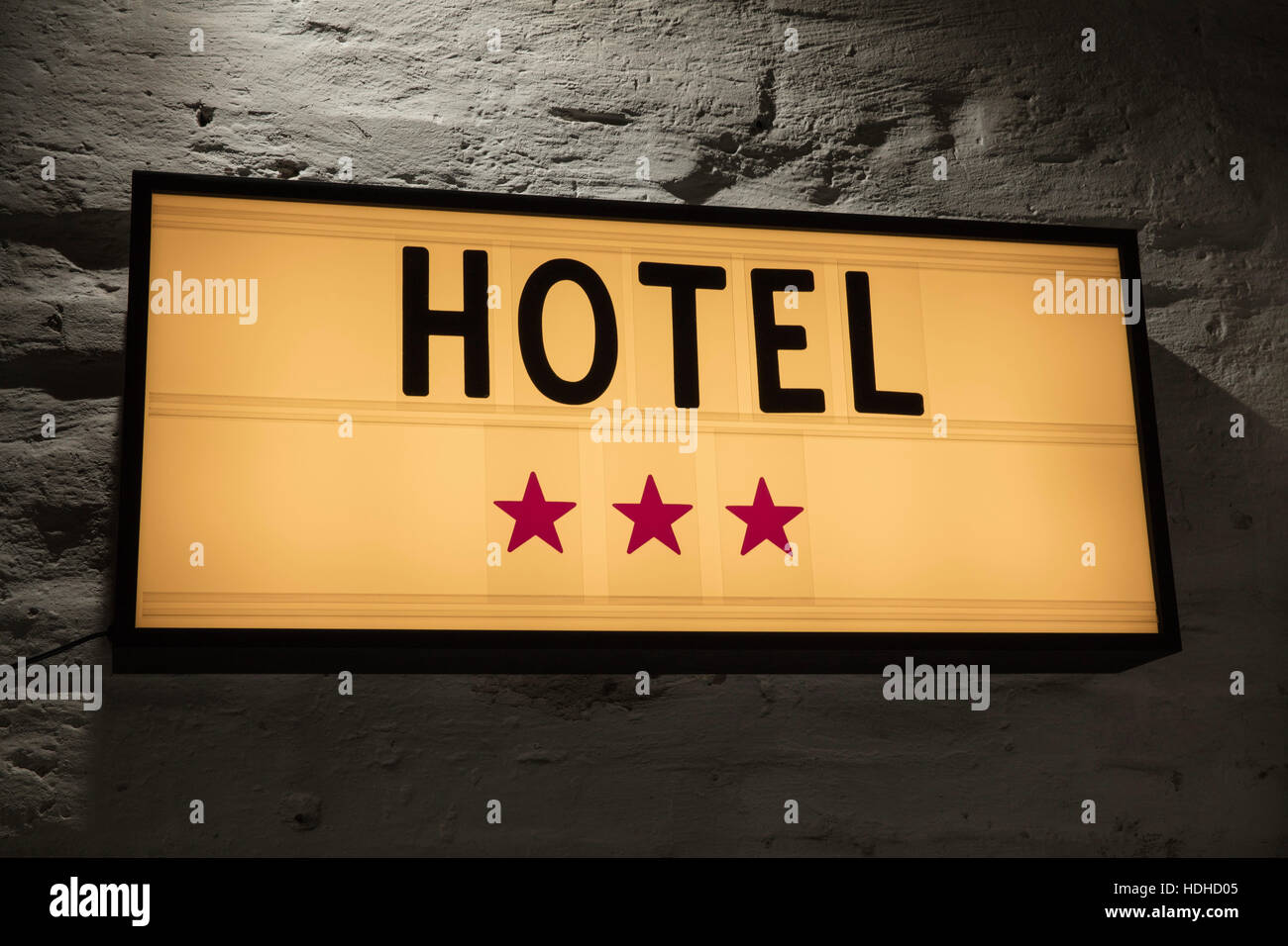 Close-up of Three Stars Hotel signboard against gray wall Stock Photo