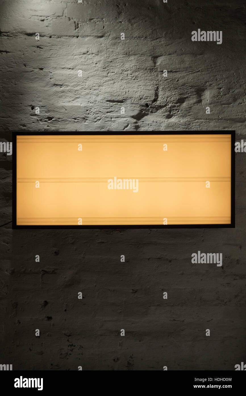 Close-up of blank illuminated signboard against gray wall Stock Photo
