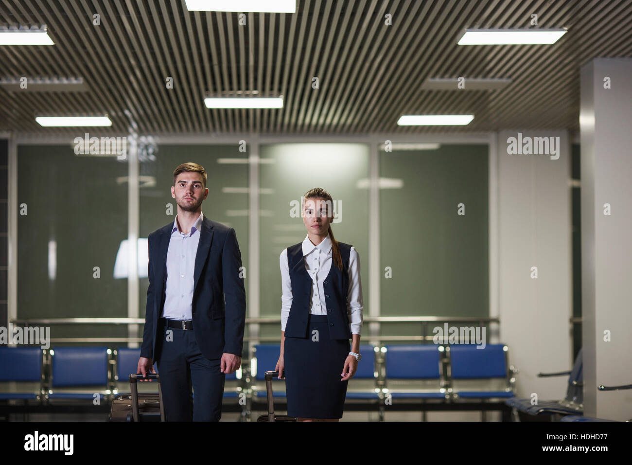 Portrait of confident young businessman and businesswoman with luggage in airport Stock Photo