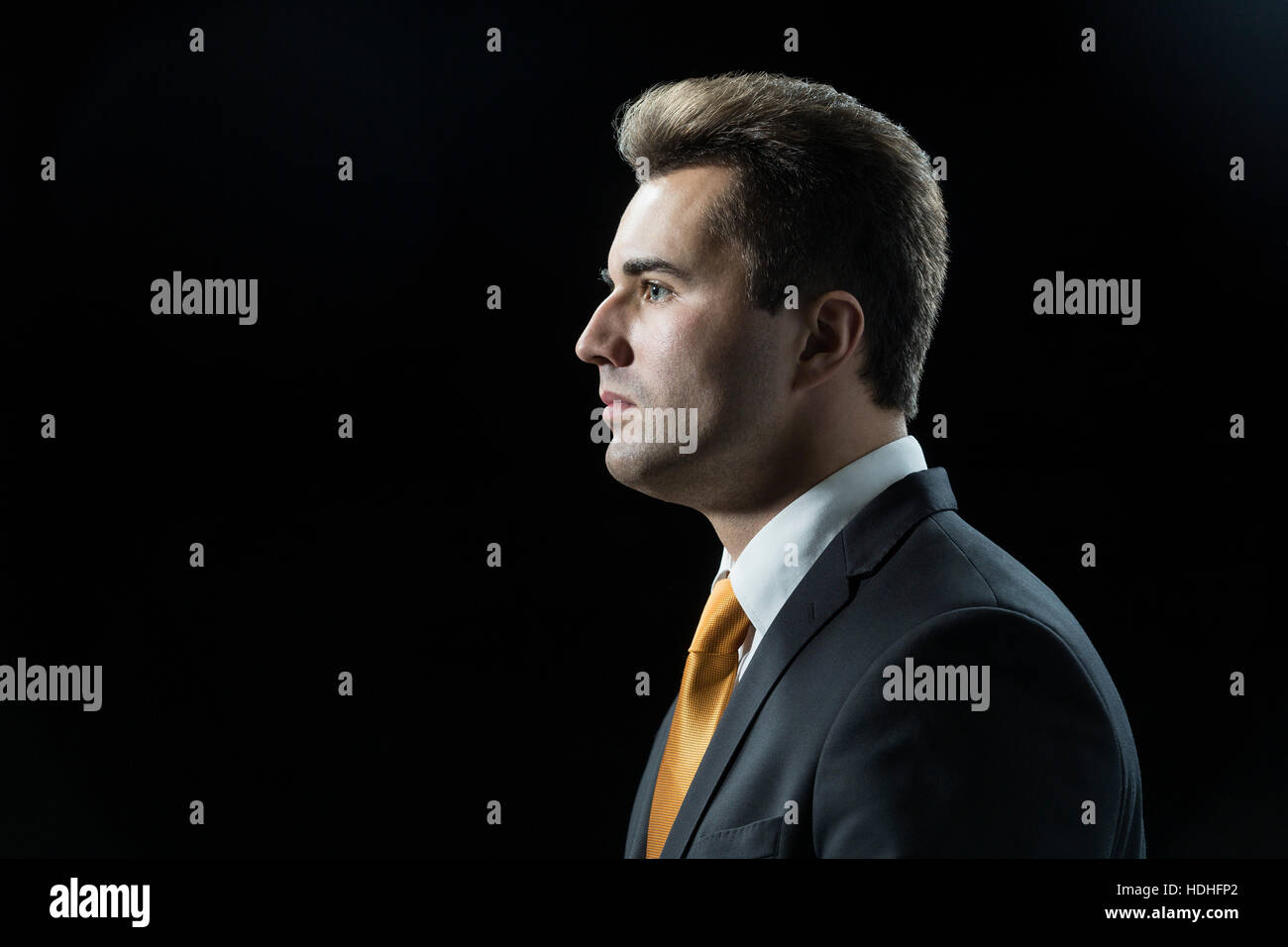 Side view of thoughtful businessman against black background Stock Photo