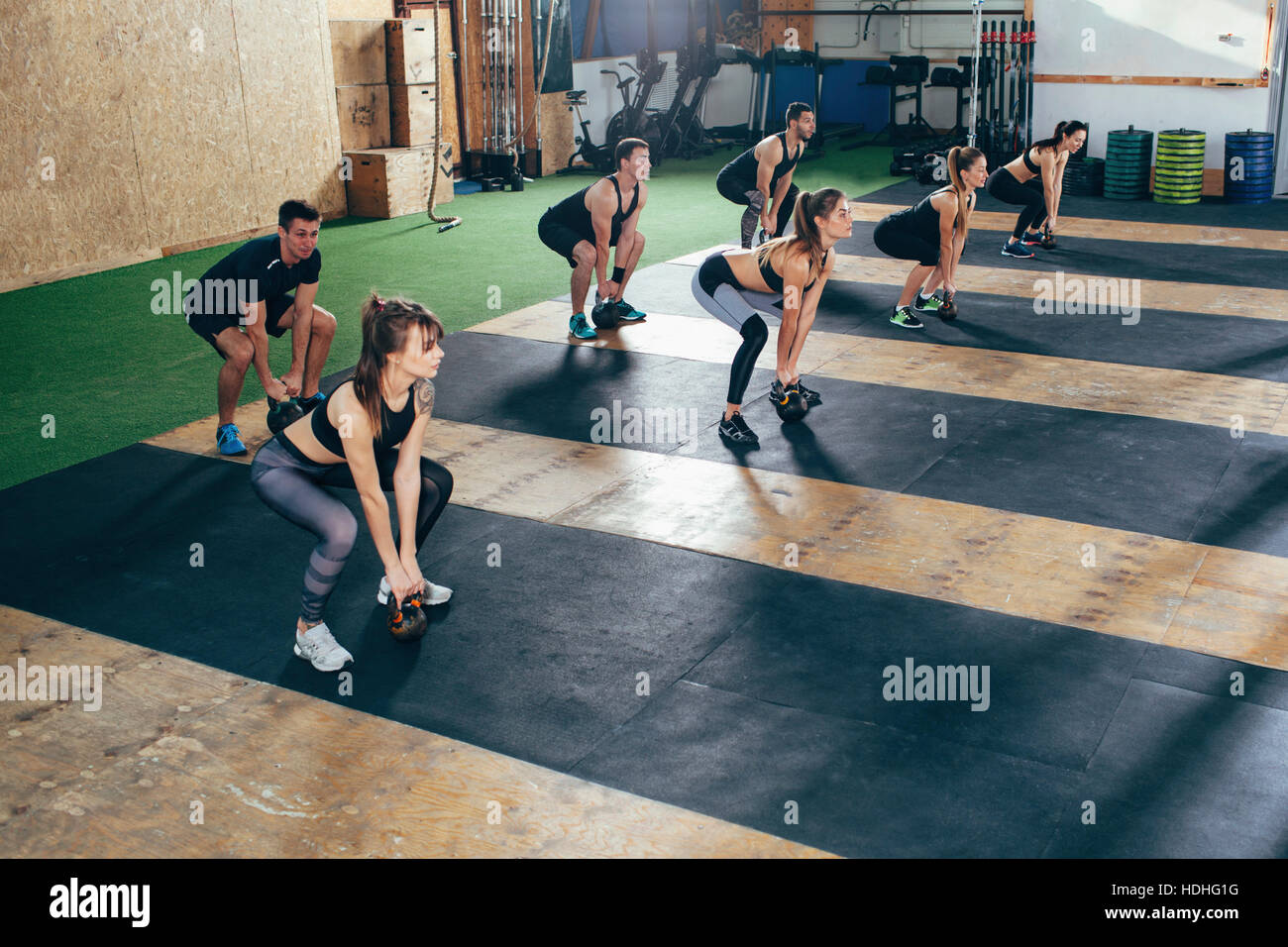 High angle view of determined athletes exercising with kettlebells at health club Stock Photo