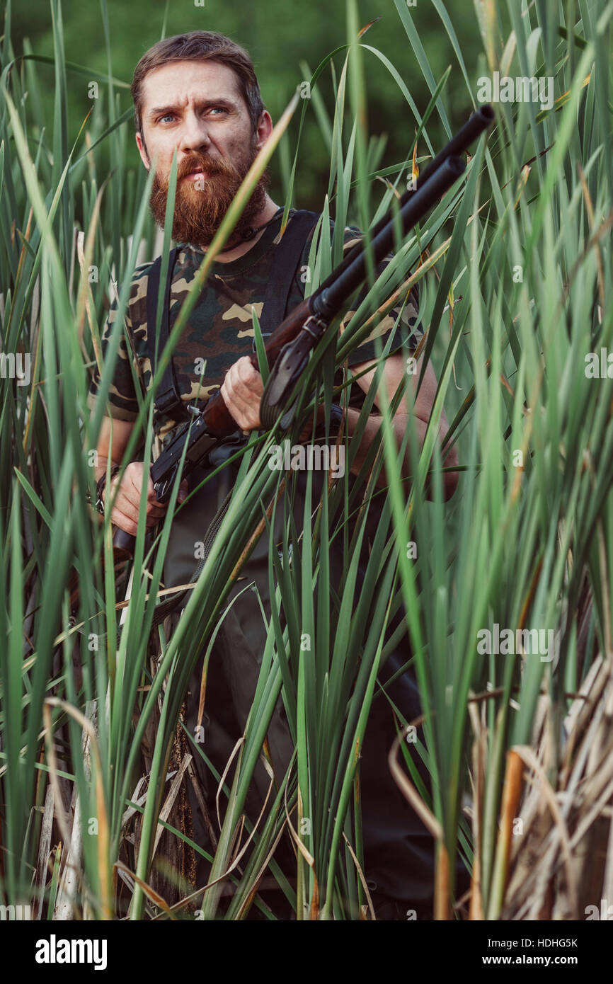 Hunter looking away while standing on grassy field Stock Photo