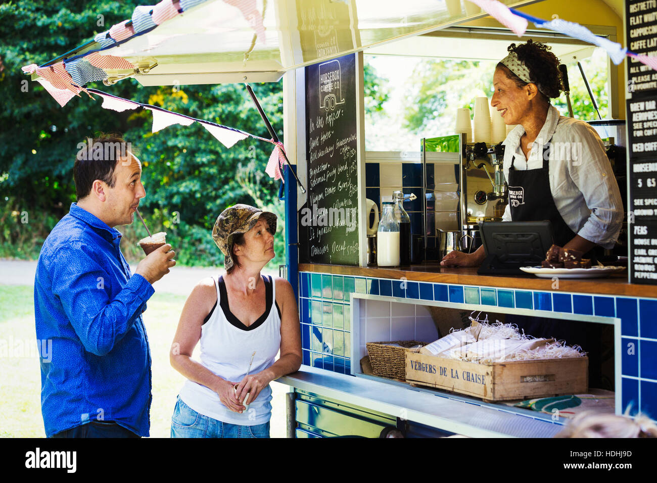 Man and woman standing at the counter of a mobile coffee shop. Stock Photo