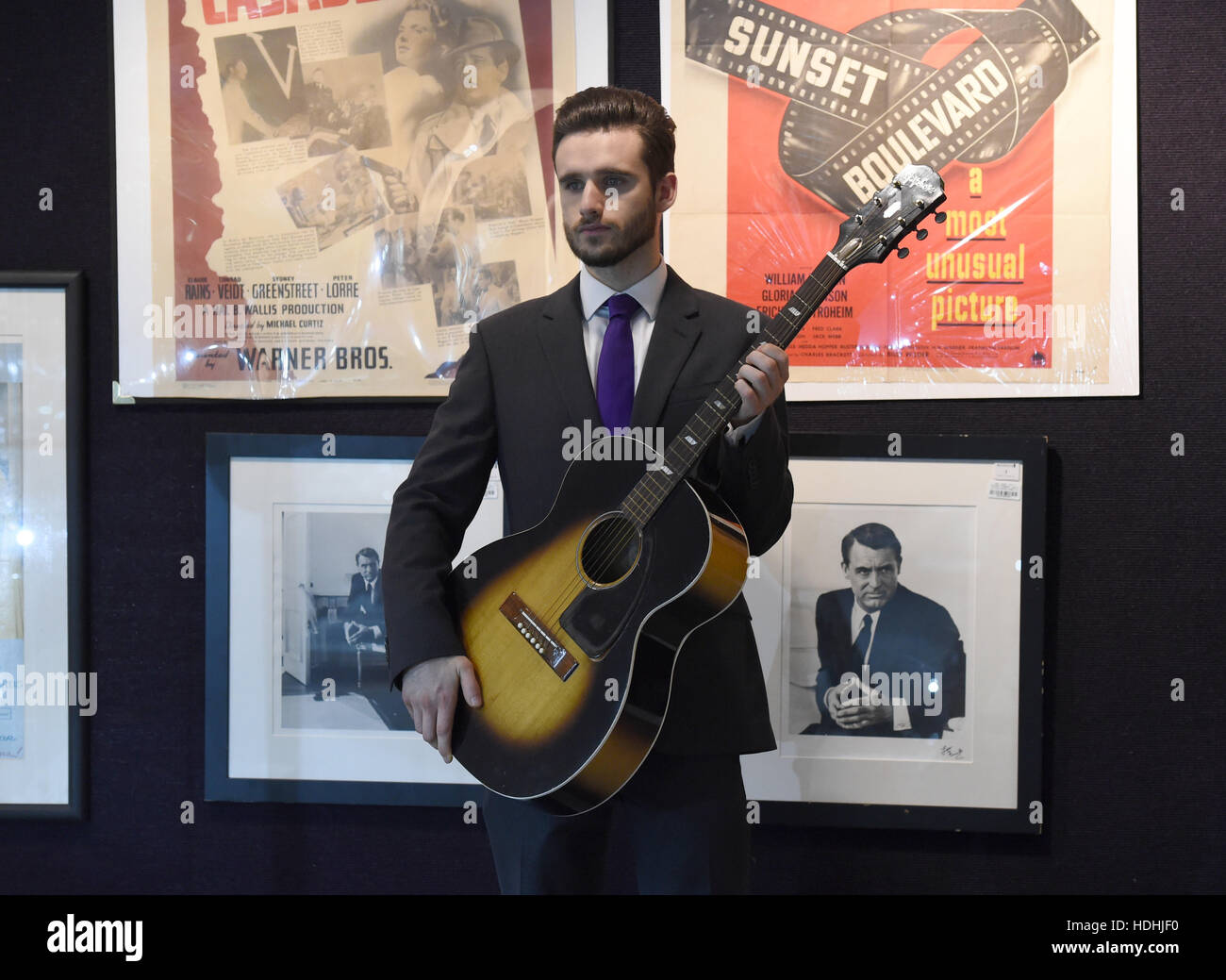 A staff member holds a guitar once owned by Jimi Hendrix on display ahead of the the Entertainment Memorabilia Sale at Bonhams in Knightsbridge, London later this week. Stock Photo