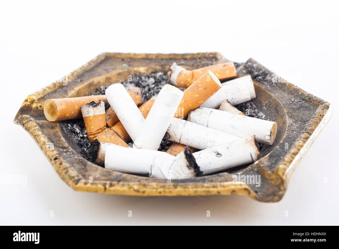 Full ashtray can illustrate your work. Copper cigarette ashtray. Dirty  ashtray in white studio background. Tobacco cigarette butts in ashtray  Stock Photo