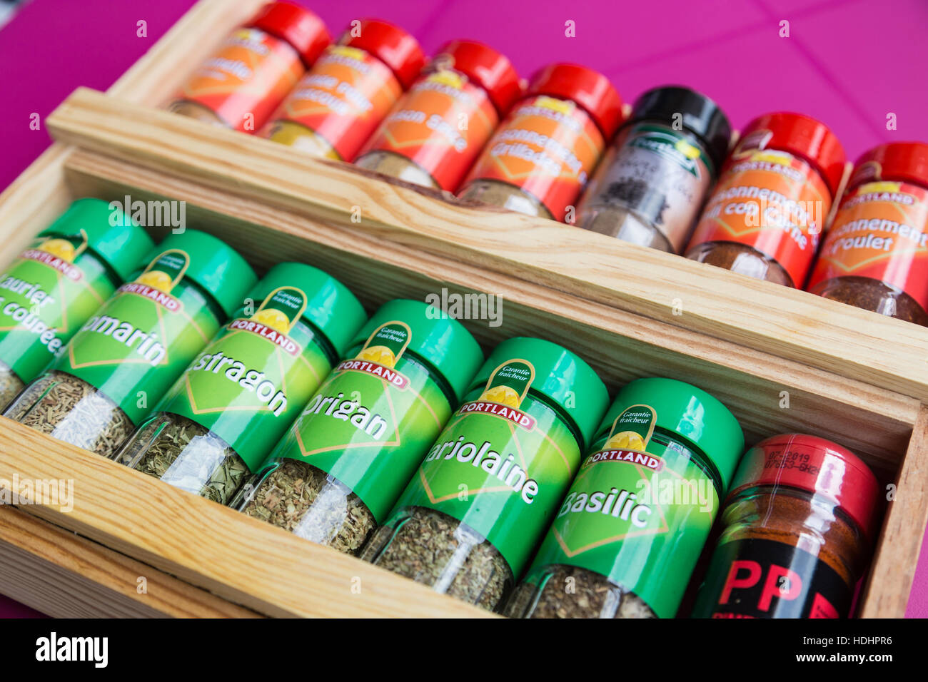 Wooden French herb and spice rack with different coloured jars Stock