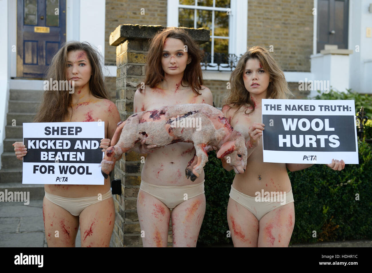 Models from animal rights group PETA are body painted to look bruised and bloodied  with one holding a dead lamb at the start of UK Wool Week.  The group say PETA’s  international affiliates have released exposes recorded at 37 facilities on three contine Stock Photo