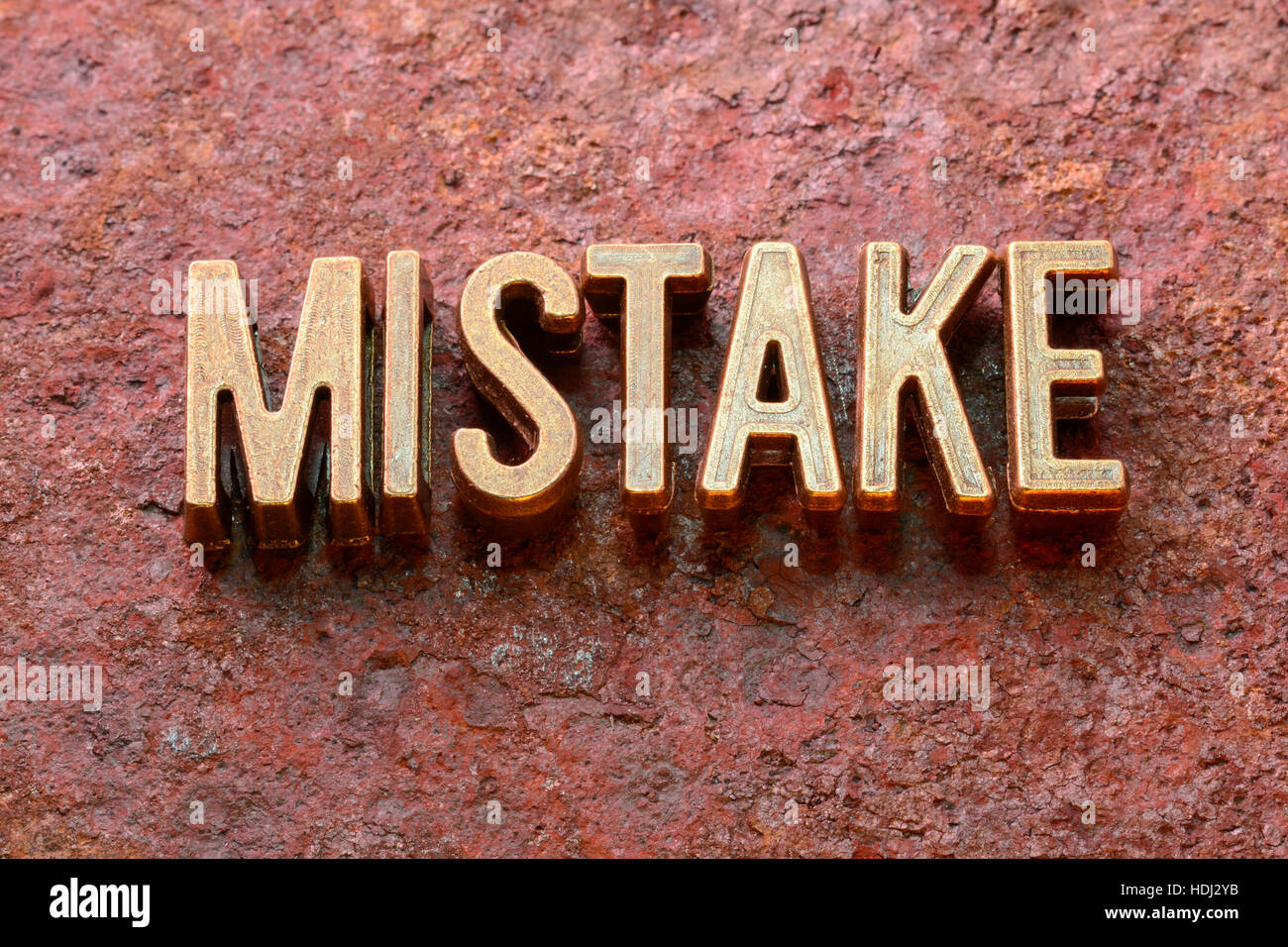 mistake word made from metallic letters on red rusty surface Stock Photo