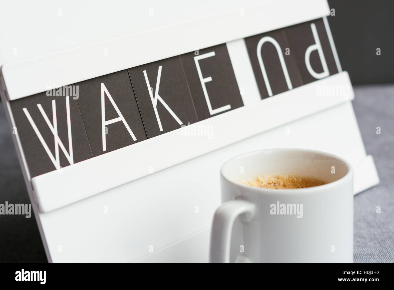 Cup of coffee in front of a board that says 'wake up' Stock Photo