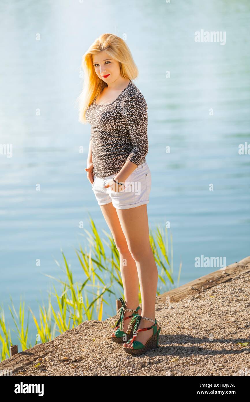 Teen girl on riverside on sunny day looking at camera eyes-contact ...